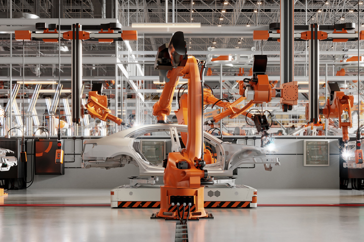 Robotic arms welding parts on cars in a production line